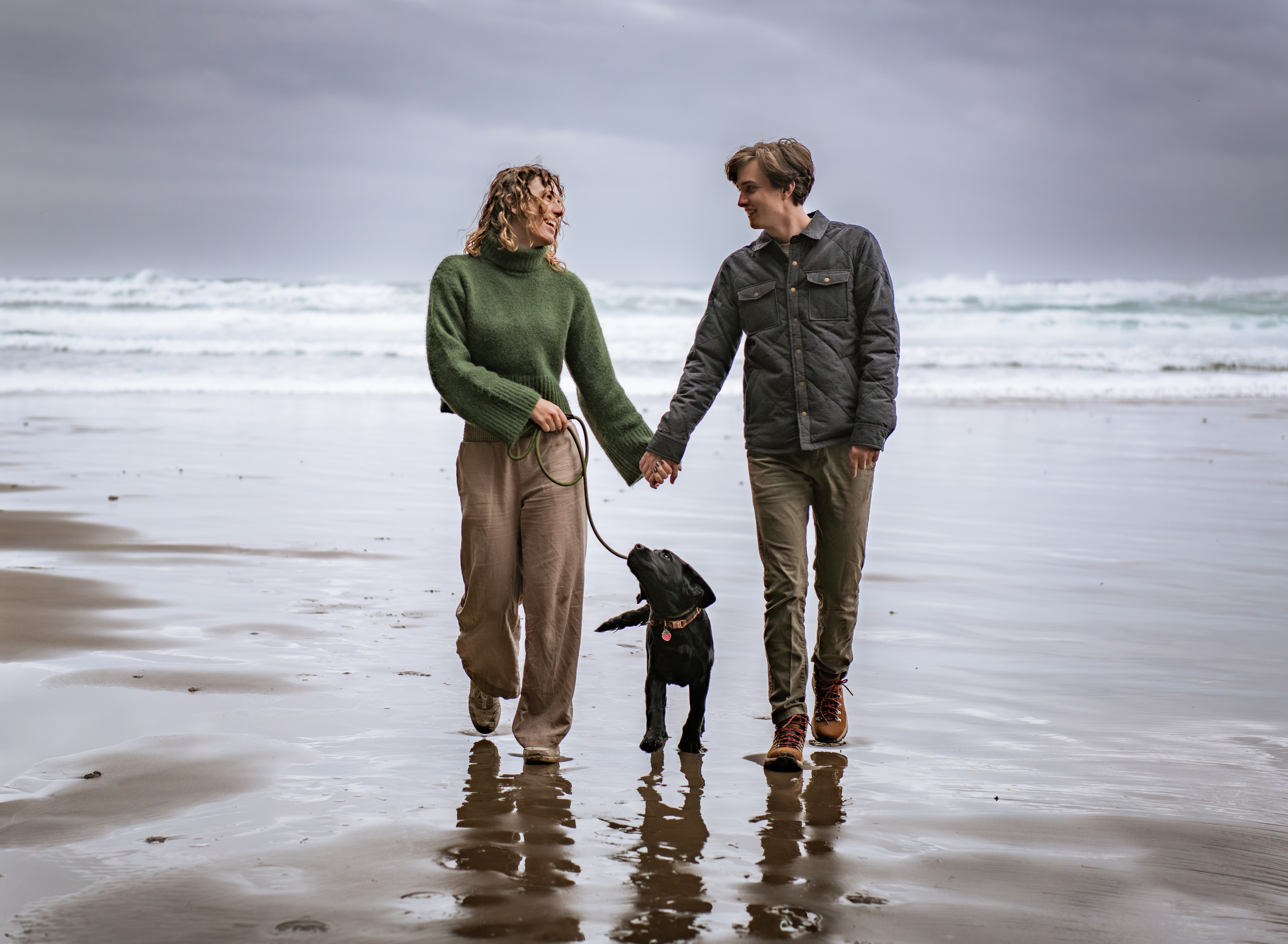 Sedge and Aryah walking with Squid down a beach.